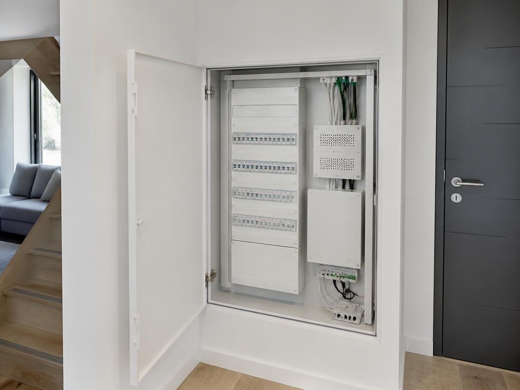 Tableau électrique et coffret de communication intégrés à l'intérieur d'un GTL dans l'entrée d'une maison neuve